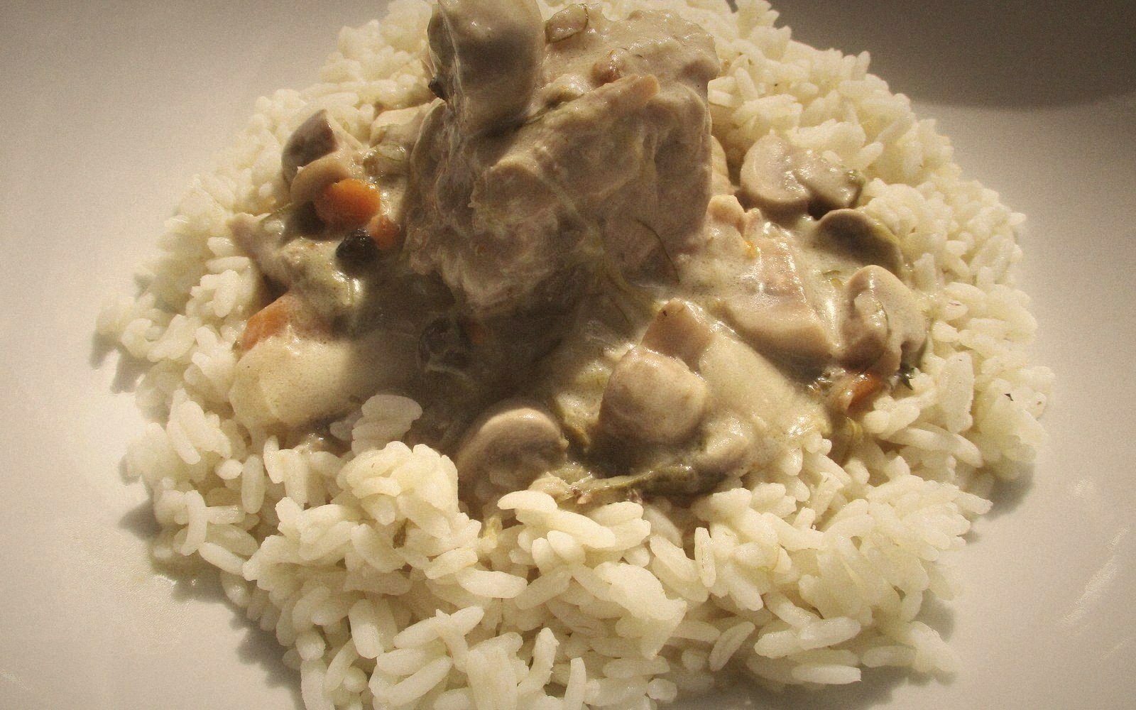 Meat and mushroom stew in creamy sauce served over a bed of rice