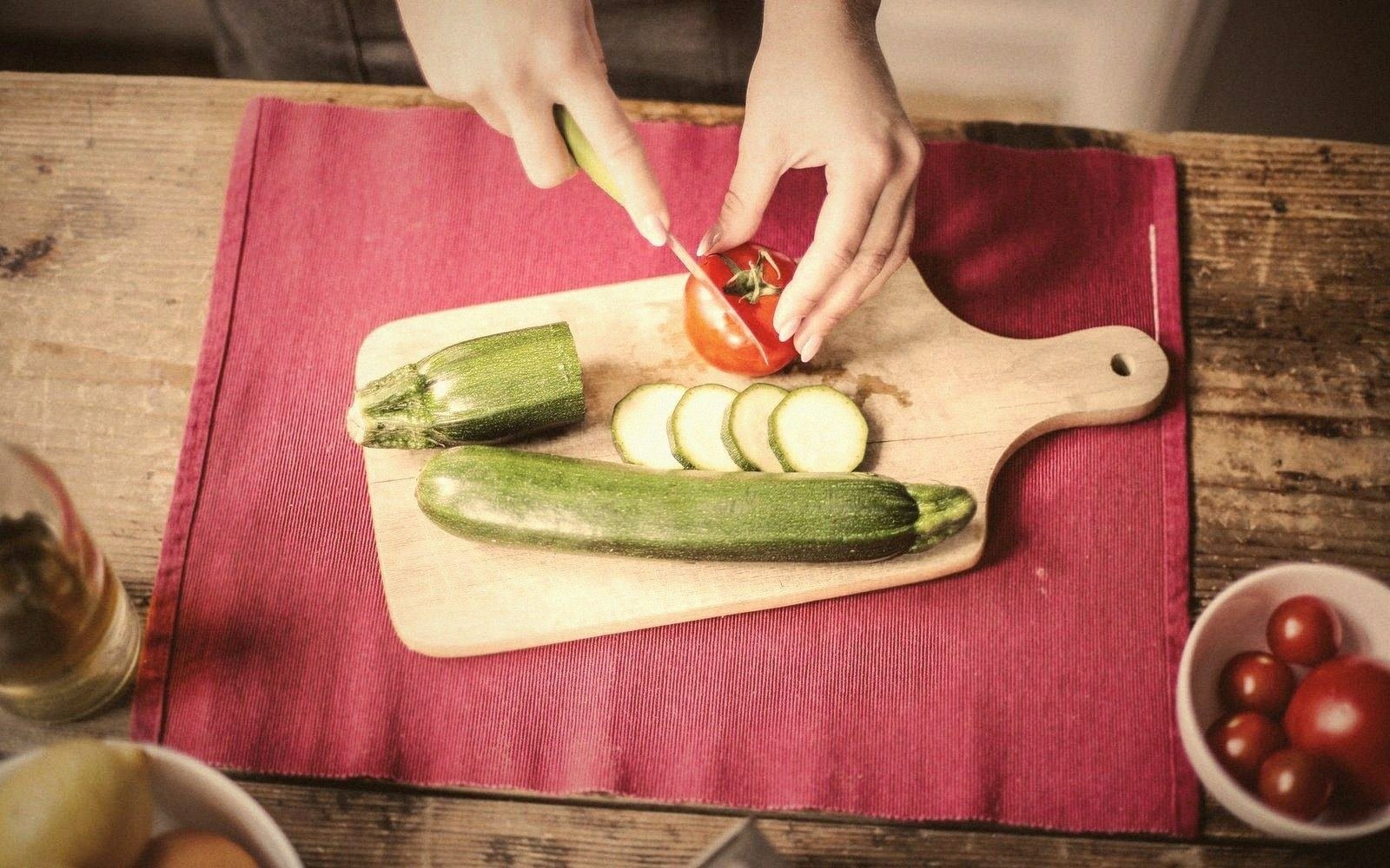 Two people prepping vegetables at a table, from above